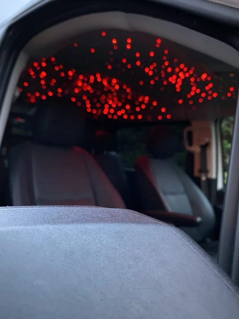 Sterrenhemel in het dak van een auto met rode verlichting